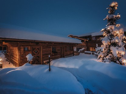 Hüttendorf - Restaurant - Allgäu - winterlich verschneites Chaletdorf am Abend - Alpzitt Chalets