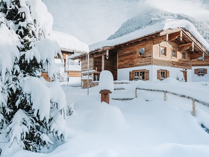 Hüttendorf - zustellbares Kinderbett - Allgäu - winterliche Außenaufnahme der Chalets - Alpzitt Chalets
