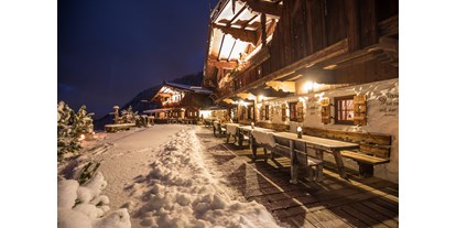 Hüttendorf - Verpflegung: All-Inclusive - Ski Juwel Alpbachtal Wildschönau - Chalet beleuchtet bei Nacht - Luxuschalet Bischofer-Bergwelt