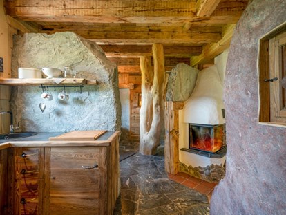 Hüttendorf - Sauna: im Chalet - Küchenbereich Wildererhütte dahinter das Bad - Almhütten Moll am Haldensee