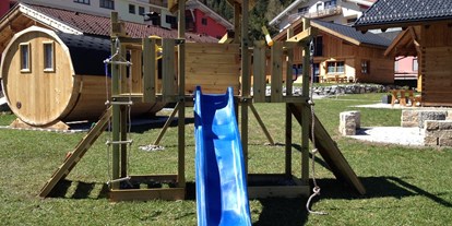 Hüttendorf - Schwerpunkt: Winterurlaub - Tirol - Außenbereich mit Spielplatz, Sauna und Grillplatz -  Lechtal Chalets