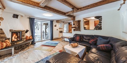 Hüttendorf - Schwerpunkt: Urlaub mit Hund - Smileys Wohnzimmer mit Ofenen Feuer und Blick auf den Fluss - Smileys Fluss Chalet