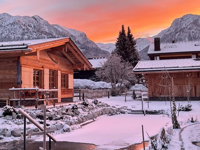 Hüttendorf - Terrasse - Morgenrot-Stimmung mit Blick zum Nebelhorn 
... im Vordergrund unser Schwimmteich, der auch im Winter unsere Sauna-Fans begeistert  - Alpglück Chalets *****