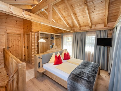 Hüttendorf - zustellbares Kinderbett - Irdning - Eltern-Schlafzimmer mit offenem Schrank, Sat-TV und Zugang zum Balkon. - Dorf-Chalets Filzmoos