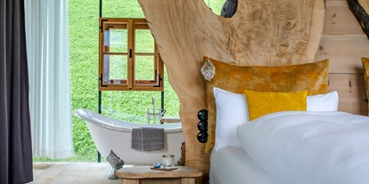 Hüttendorf - Küche - Schlafzimmer mit freistehender Badewanne in der Villa ETANER - PRIESTEREGG Premium ECO Resort