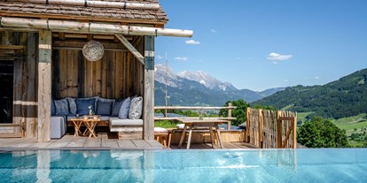 Hüttendorf - Pools: Außenpool - Beheizter Infinitypool mit Panoramabergblick im PRIESTEREGG BAD - PRIESTEREGG Premium ECO Resort