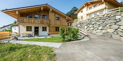 Hüttendorf - zustellbares Kinderbett - Allgäu - Aussenansicht im Sommer - Waldchalets Allgäu