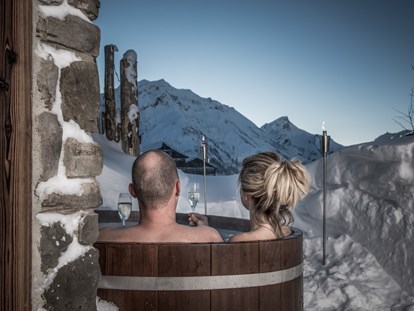 Hüttendorf - Schwerpunkt: Skiurlaub - Pfunds - Lass dich fallen und tauche ein ins wärmende Wasser deines privaten Holzzubers. Draußen am Rande der Terrasse, sichtgeschützt und nur für dich – wann immer du möchtest - Aadla Walser-Chalets am Arlberg