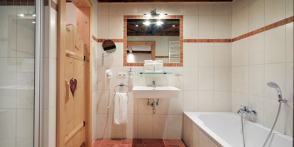 Hüttendorf - Küche - Katschberghöhe - Badezimmer en suite mit Badewanne/Dusche/WC/Fön/Kosmetikspiegel - Almdorf Flachau