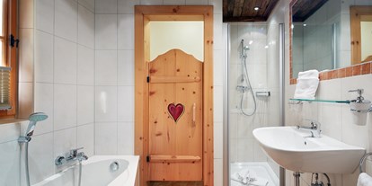 Hüttendorf - King Size Bett - Flachau - Badezimmer en suite mit Badewanne/Dusche/WC/Fön/Kosmetikspiegel - Almdorf Flachau
