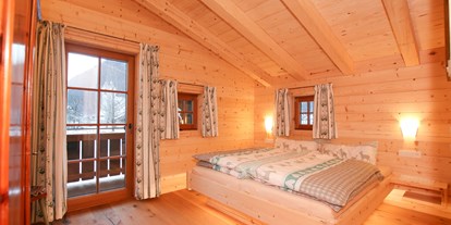 Hüttendorf - Umgebungsschwerpunkt: Berg - Pinzgau - Eines der beiden gemütlichen Schlafzimmer, mit hochwertigem Holz eingerichtet - Chalet am Müllergut