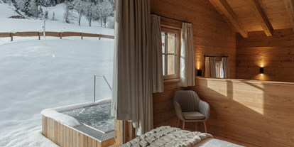 Hüttendorf - King Size Bett - Tiroler Unterland - Schlafzimmer mit Ausblick zum privaten Whirlpool - Hygna Chalets