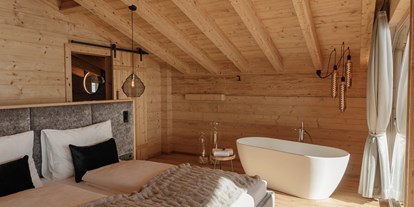 Hüttendorf - WLAN - Tiroler Unterland - Schlafzimmer mit Badewanne - Hygna Chalets