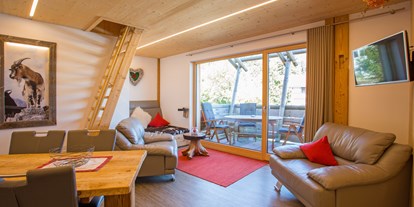 Hüttendorf - Rauchen: nur im Freien erlaubt - Deutschland - Wohnzimmer mit Treppe zur Schlafhöhle im 1.Stock Dorf-Chalet
 - Dorf Chalet