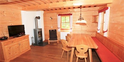 Hüttendorf - Typ: Blockhütte - Österreich - Stube in der Hütte mit Kaminofen - Hüttendorf Dachsteinblick