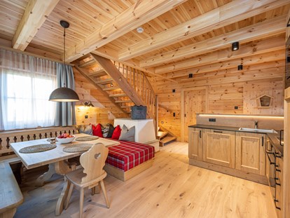 Hüttendorf - Pongau - Wohn / Essbereich mit Elektroofen und Küchenzeile.
Treppe nach oben zu den Schlafzimmern. - Dorf-Chalets Filzmoos