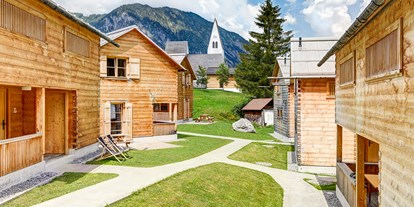 Hüttendorf - Vorarlberg - Casalpin-Chalet-Dorfe mit Sicht auf die Kirche - Casalpin Chalets in Brand