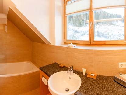 Hüttendorf - zustellbares Kinderbett - Badezimmer mit Badewanne - Trattlers Hof-Chalets