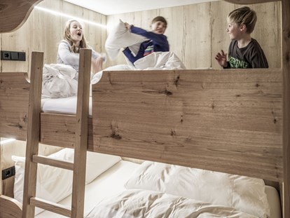 Hüttendorf - offener Kamin - Das XXL Etagenbett (fast so breit wie ein Doppelbett) ist der Lieblingsplatz der Kinder. Bis zu 4 Personen finden hier Platz. - Aadla Walser-Chalets am Arlberg