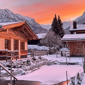 Chalet: Morgenrot-Stimmung mit Blick zum Nebelhorn 
... im Vordergrund unser Schwimmteich, der auch im Winter unsere Sauna-Fans begeistert  - Alpglück Chalets *****