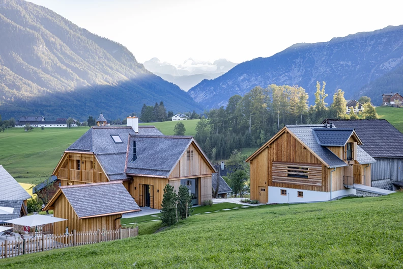 Chalets in Morgenstimmung mit Bergen im Hintergrund