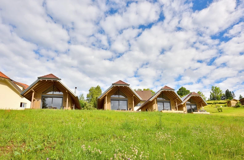 Au&szlig;enaufnahme Holzchalets mit Wolkenhimmel