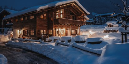 Hüttendorf - zustellbares Kinderbett - PLZ 6764 (Österreich) - winterliches Chaletdorf am Abend - Alpzitt Chalets