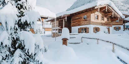 Hüttendorf - Kachelofen - Höfen (Höfen) - winterliche Außenaufnahme der Chalets - Alpzitt Chalets