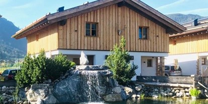 Hüttendorf - Umgebungsschwerpunkt: Therme - Abtenau - Eines unserer Chalet Hütten mit unserem Naturschwimmteich davor.  - Sieglhub Chalets Appartements Hotel