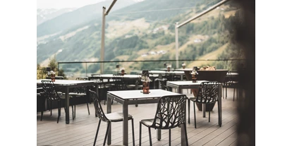 Hüttendorf - Restaurant - Untergarten - Unsere Sonnenterrasse mit traumhaften Ausblick auf die umliegende Berglandschaft. - Boutique Hotel und Chalets Bergwiesenglück