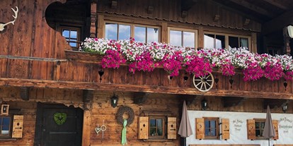 Hüttendorf - Massagen: im Chalet - Oed (Walchsee) - Sommeransicht mit Blumen - Luxuschalet Bischofer-Bergwelt