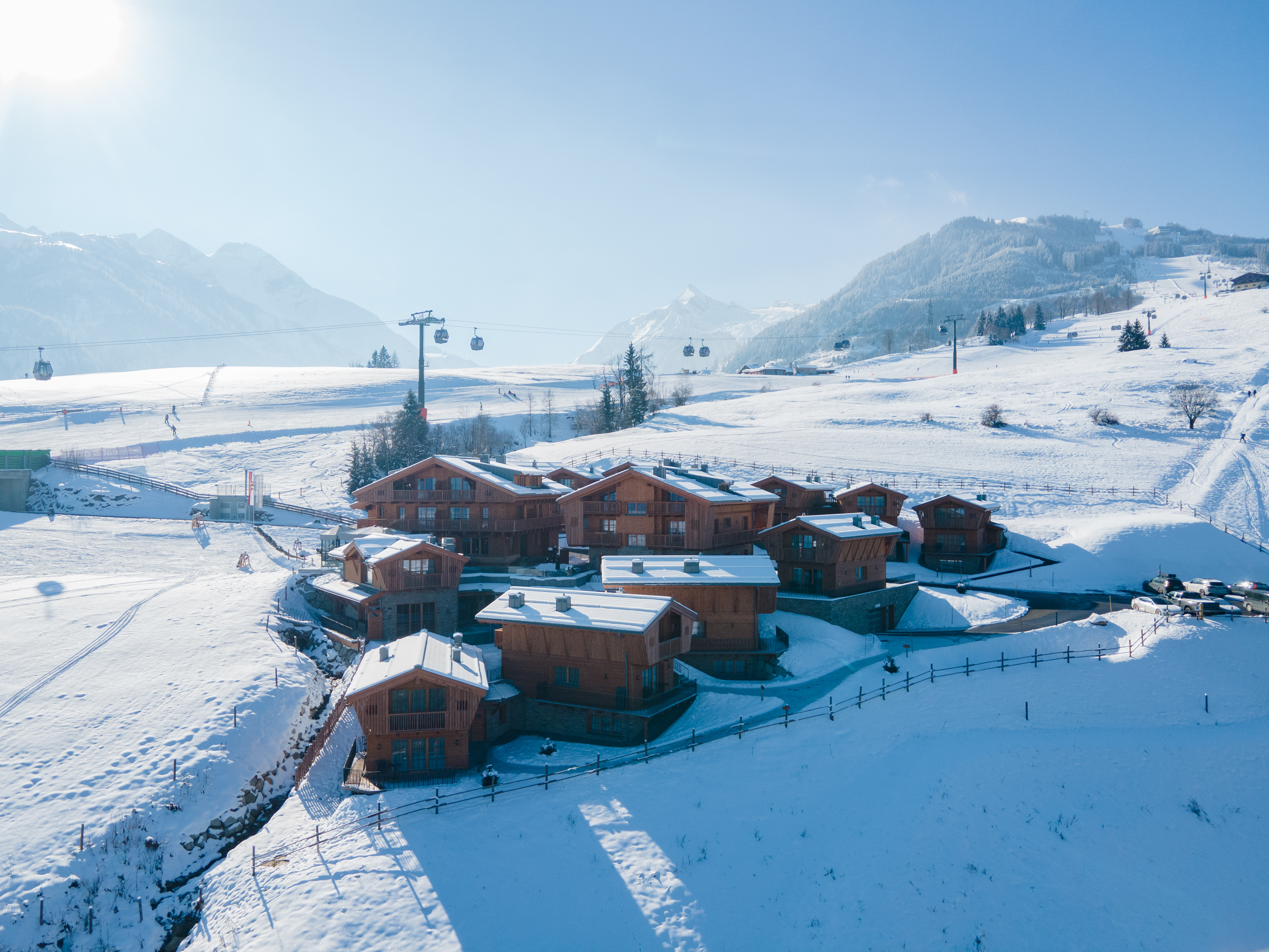 Hüttendorf: Das Zaglgut präsentiert sich inmitten einer verschneiten Winterlandschaft – umgeben von Bergen, Ruhe und der besonderen Atmosphäre eines Winterurlaubs in den Alpen - Bergdorf Hotel Zaglgut Ski In & Ski Out