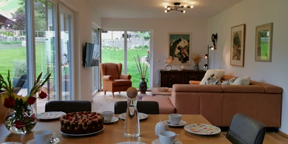 Hüttendorf - Doppelbett - Göriach (Dölsach) - Essensbereich & Wohnzimmer mit Blick auf Garten und Bergwelt - Lodge Sirius  - TYROL PURElife Lodges 