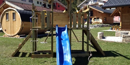 Hüttendorf - Schwerpunkt: Winterurlaub - Untergarten - Außenbereich mit Spielplatz, Sauna und Grillplatz -  Lechtal Chalets