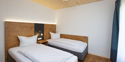 Hüttendorf - zustellbares Kinderbett - Halfing - Schlafzimmer mit 2 Einzelbetten - Niederauer Hof Chalets