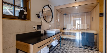 Hüttendorf - Doppelbett - Grillenhöfe - Badzimmer und Sauna im Untergeschoss - Hideaway Hotel Montestyria Chalets & Suiten