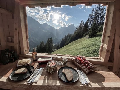 Hüttendorf - Frühstück: Frühstückservice - Vorarlberg - Für spezielle naturerlebnisse verwöhnen wir dich mit einem Raclette im Hochstand. Der Sonnenuntergang hier ist besonders schön! - Aadla Walser-Chalets am Arlberg