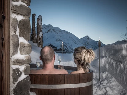 Hüttendorf - Schwerpunkt: Winterurlaub - Hochasten - Lass dich fallen und tauche ein ins wärmende Wasser deines privaten Holzzubers. Draußen am Rande der Terrasse, sichtgeschützt und nur für dich – wann immer du möchtest - Aadla Walser-Chalets am Arlberg
