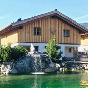 Hüttendorf: Eines unserer Chalet Hütten mit unserem Naturschwimmteich davor.  - Sieglhub Chalets Appartements Hotel