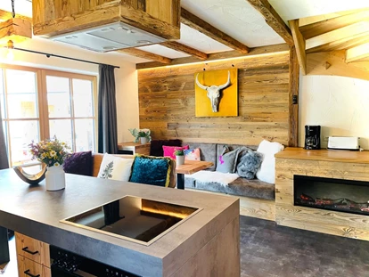 Hüttendorf - Snow Space Salzburg - Flachau - Wagrain - St. Johann - Die Couchecke mit einem Elektrokamin. - Sieglhub Chalets Appartements Hotel