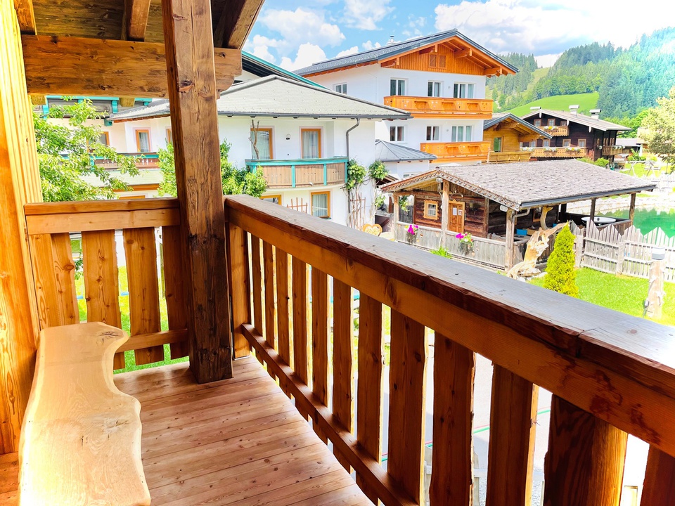 Chalet: Blick auf unser Stamm- und Appartmenthaus und dem Naturschwimmteich. - Sieglhub Chalets Appartements Hotel - Außen