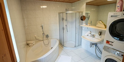 Hüttendorf - Chaletgröße: 8 - 10 Personen - Badezimmer 1 – mit Dusche, Badewanne, Waschbecken, Spiegel, Kosmetikspiegel, Haartrockner, Waschmaschine und Wäschetrockner - Beim Rauter – Emberger Alm
