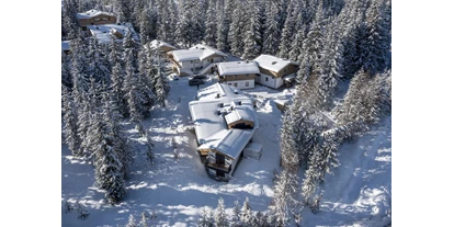 Hüttendorf - Chaletgröße: 4 - 6 Personen - Pinzgau - Sam-Alm von obenWer Schnee sucht, ist in Hochkrimml an der richtigen Adresse. Der ganz auf Wintersportler zugeschnittene Ferienort bietet sonnige und beschneite Pistenabfahrten mit einer langen Saison von Anfang Dezember bis weit in den April. Der Ort selbst ist ruhiger als das benachbarte Königsleiten und damit ideal für Gäste, die Besinnlichkeit mögen. Gleichwohl gibt es hier Gelegenheiten zur abendlichen Entspannung. Kein Wunder, dass Hochkrimml immer beliebter wird. 
 
Warum entscheidet man sich für die hochgelegenen Alpenorte? Weil sie dem Himmel näher sind und eine atemberaubende Aussicht bieten! Das Gefühl, aus dem Haus zu kommen, bereits auf den Brettern zu stehen und direkt ins Tal zu wedeln, ist einfach unvergleichlich – wobei „Tal“ vielleicht nicht der richtige Begriff ist, denn der niedrigste Punkt ist immer noch etwa 1400 Meter hoch gelegen. Auf der anderen Seite erobern Sie über Königsleiten die Weiten der Gerlosplatte. Aber auch in Hochkrimml finden Sie genügend Infrastruktur für den Skifahrer: neben modernen Liften haben Sie hier eine Skischule und ein Skigeschäft mit Skiverleih direkt im Dorf. Auch der Bus steht Ihnen zur Verfügung: Er verkehrt in alle nahegelegenen Skiorte: Neukirchen, Wald, Krimml und Königsleiten.
Wenn Sie weniger Adrenalin beim Sport brauchen, können Sie von hier aus herrliche, liebevoll vorbereitete Langlaufloipen nutzen. Auch eine Rodelabfahrt steht Ihnen zur Verfügung. Oder ist Ihnen eher nach einer zünftigen Winterwanderung zumute? Dann empfehlen wir Ihnen eine Schneeschuhwanderung, zum Beispiel an die Krimmler Wasserfälle, die auch im Winter sehr beeindruckend sind. Über 300 Meter stürzt das Wasser hier den Fels hinab. - Sam-Alm