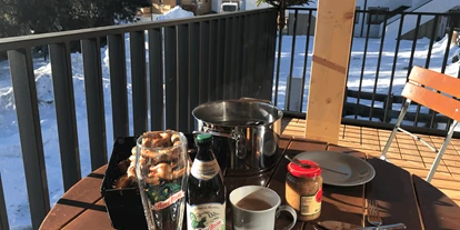 Hüttendorf - Chaletgröße: 4 - 6 Personen - Pinzgau - Weißwurstfrühschoppen auf dem Sonnenbalkon im Winter Wohnung Top3 - Sam-Alm