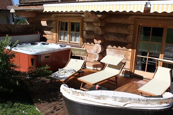 Chalet: Terrasse mit Whirlpool am Naturstammhaus - Chalets&Suiten Beim Waicher
