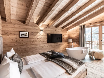 Hüttendorf - Schröcken - Schlafzimmer im Berg-Chalet mit freistehender Badewanne und Bergblick. - Benglerwald Berg Chaletdorf