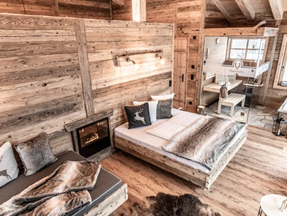 Hüttendorf - Schröcken - Wohn-/Schlafbereich im Stein-Chalet mit Sauna, Daybed und Badewanne mit Bergblick. - Benglerwald Berg Chaletdorf