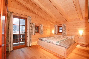 Chalet: Eines der beiden gemütlichen Schlafzimmer, mit hochwertigem Holz eingerichtet - Chalet am Müllergut