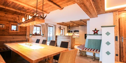 Hüttendorf - Chaletgröße: 8 - 10 Personen - Das gemütliche Ess- und Wohnzimmer mit Kachelofen und Altholz lädt zum verweilen ein. - Chalet am Müllergut