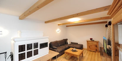 Hüttendorf - Chaletgröße: 4 - 6 Personen - Pinzgau - Chalet Glemmtal - Haus Dorfblick Wohnzimmer mit Kachelofen - Chalet Glemmtal